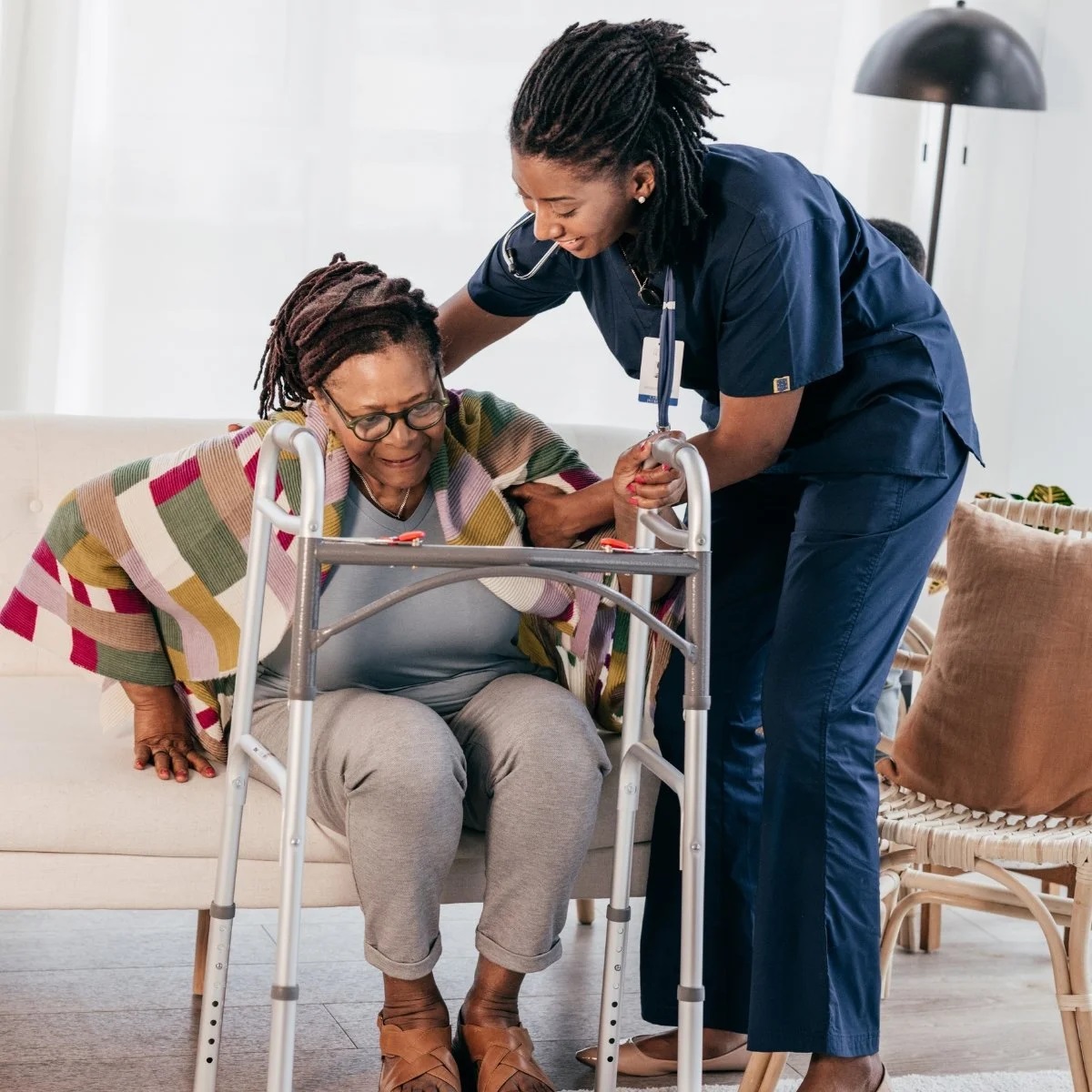 Black Female Caregiver Assisting Patient with Walker